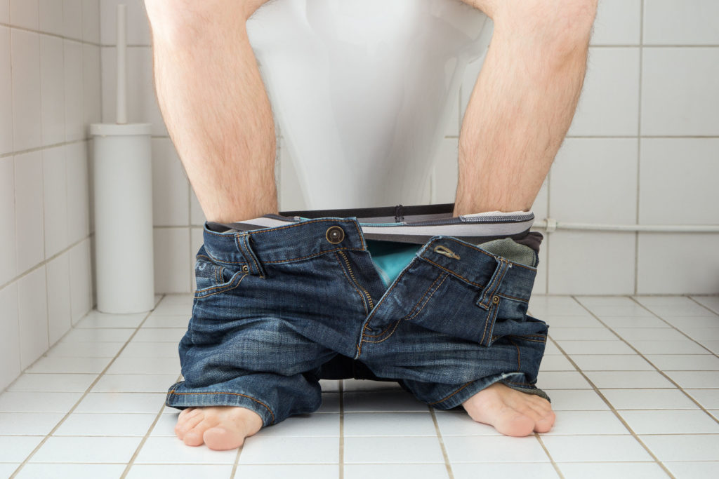 35803741 - man sitting on a toilet seat with his pants and boxers down