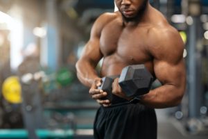 Cropped of black bodybuilder exercising with barbell
