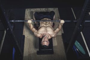 Physical athlete doing barbell bench presses