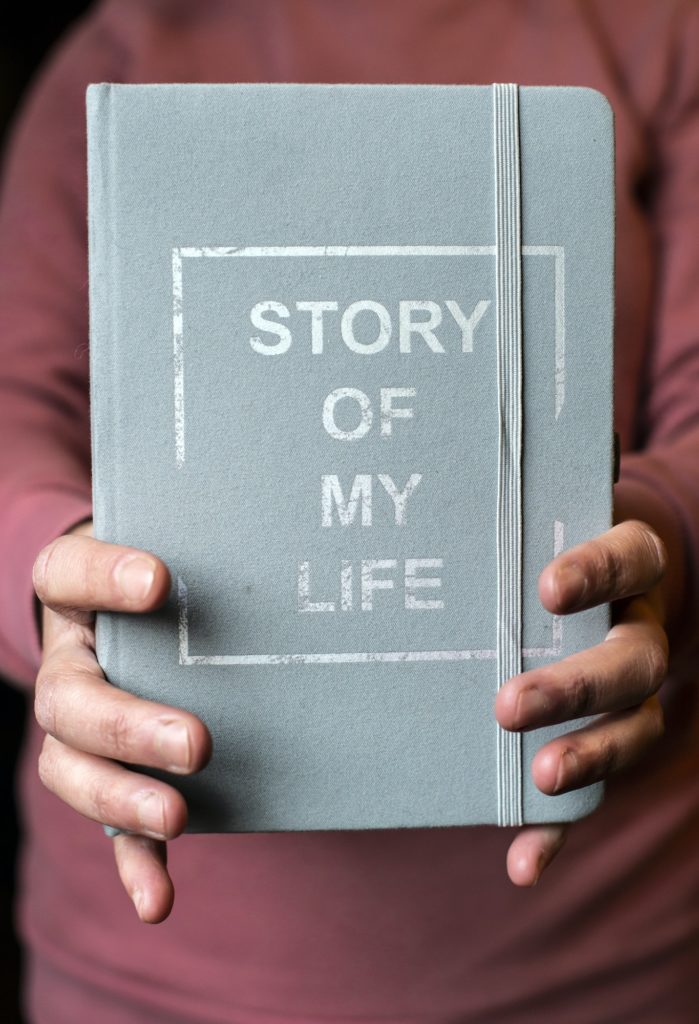 Woman hold notebook. Book notes for the Story of my life. Personal memoirs notes concept.